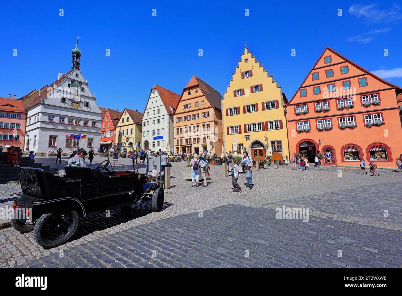 Touriste appréciant Markplatz avec des maisons traditionnelles et voiture de collection au premier plan. Banque D'Images
