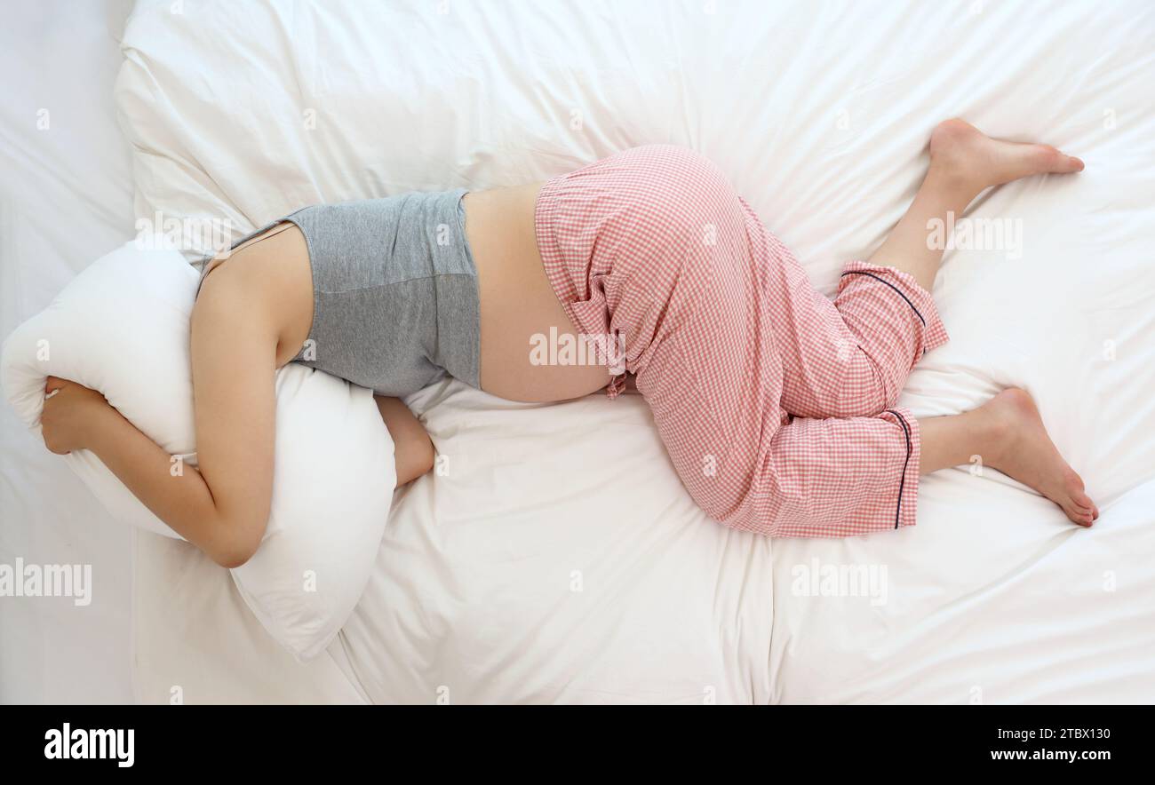 Femmes enceintes souffrant de bruit entre les étages et d'insomnie Banque D'Images