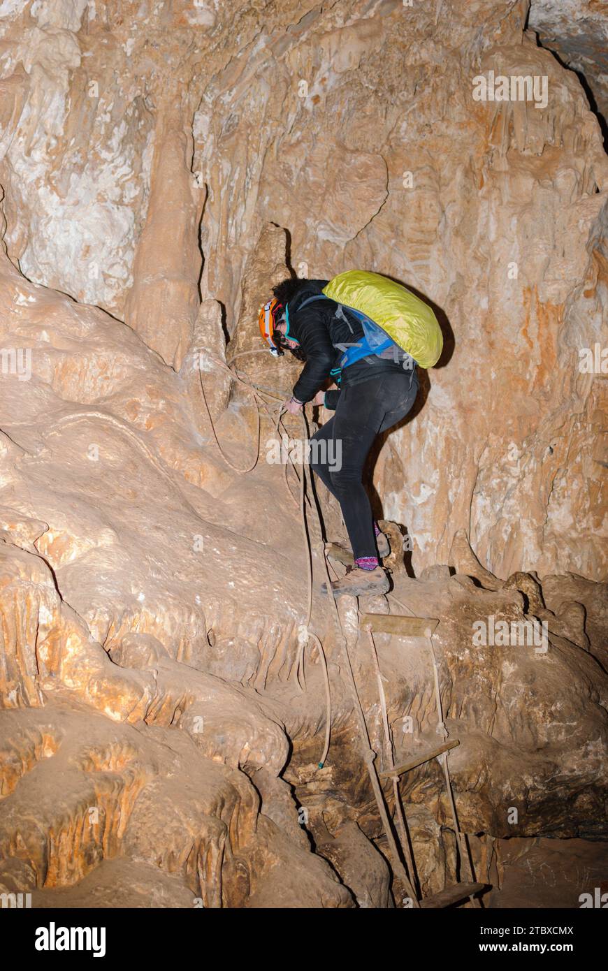 Jeune femme spelunking dans une grotte. Concept de sport féminin extrême. Banque D'Images