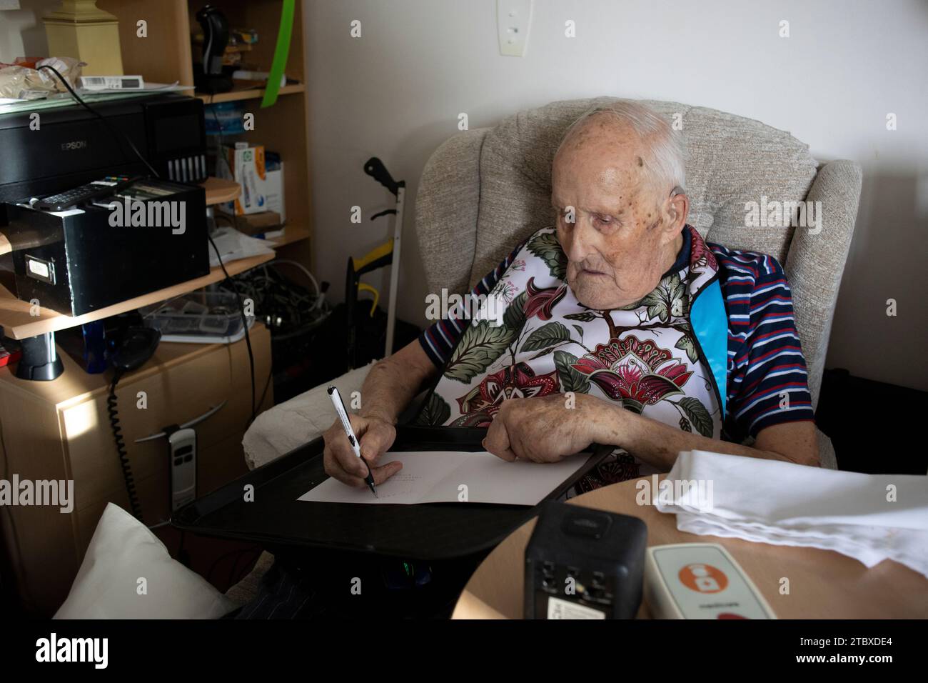 Homme âgé dans ses années 90 écrivant ses cartes de Noël à des parents avant la saison des fêtes, Angleterre, Royaume-Uni Banque D'Images