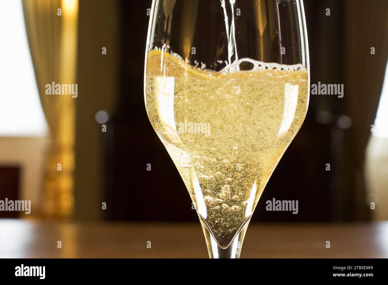Champagne pétillant dans un verre dans une salle de fête - gros plan Banque D'Images