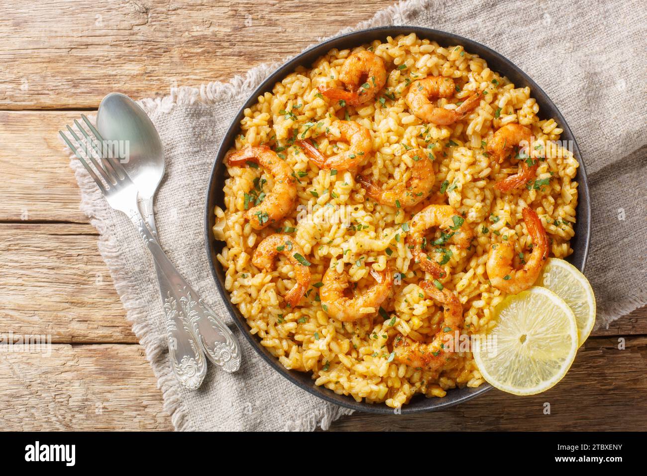 Risotto aux crevettes alliant les saveurs audacieuses du parmesan et du citron avec du riz crémeux et des crevettes juteuses closeup sur l'assiette sur la table en bois. T horizontal Banque D'Images