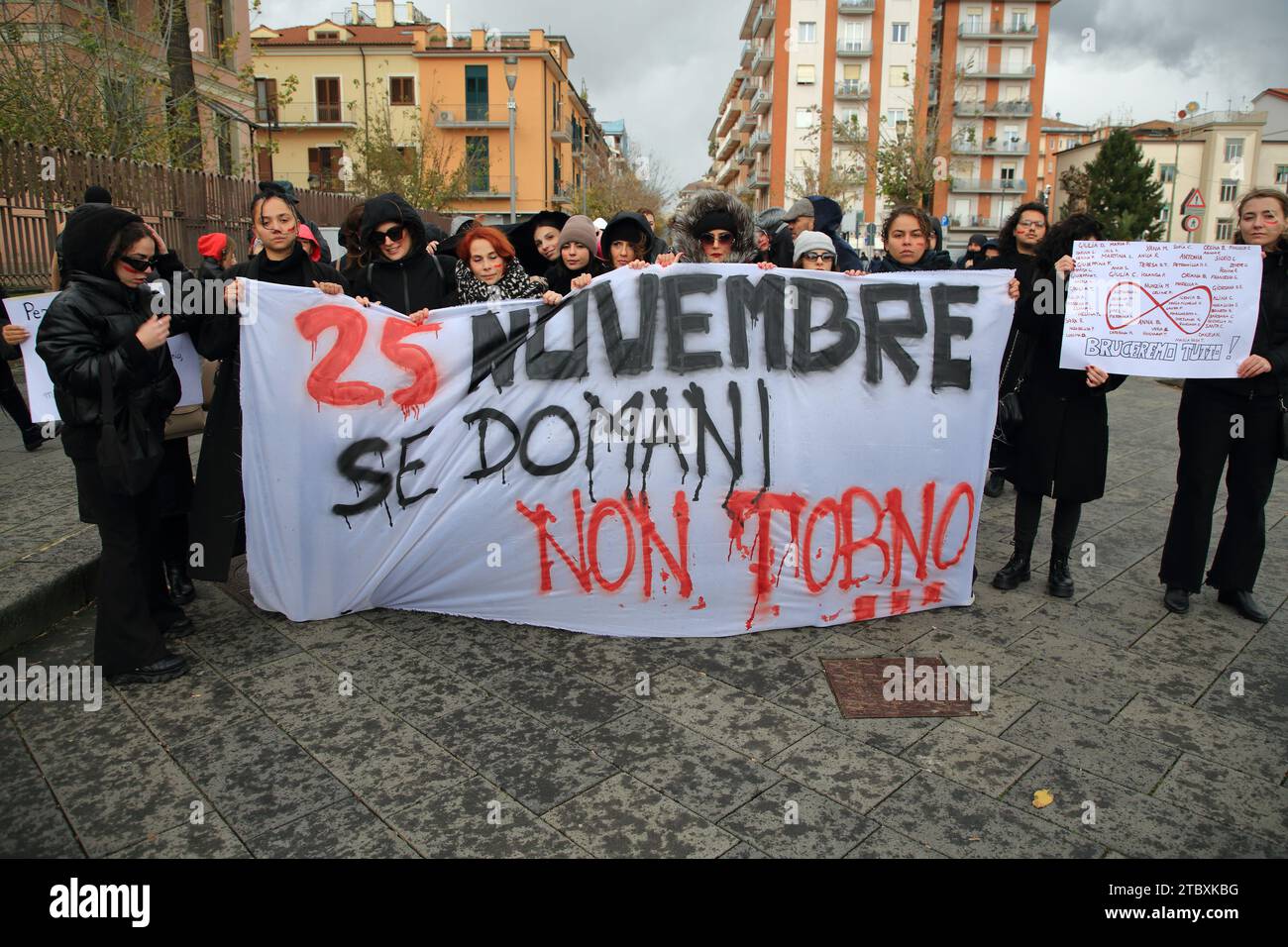 Les femmes défilent pour protester contre les meurtres de femmes par les maris et les fiduciaires lors de la journée internationale contre la violence à l'égard des femmes. Les femmes montrent un panneau. Banque D'Images