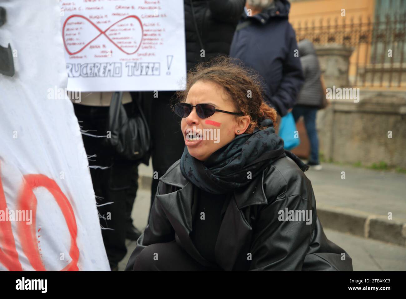Les femmes défilent pour protester contre les meurtres de femmes par les maris et les fiduciaires lors de la journée internationale contre la violence à l'égard des femmes. Les femmes montrent un panneau. Banque D'Images