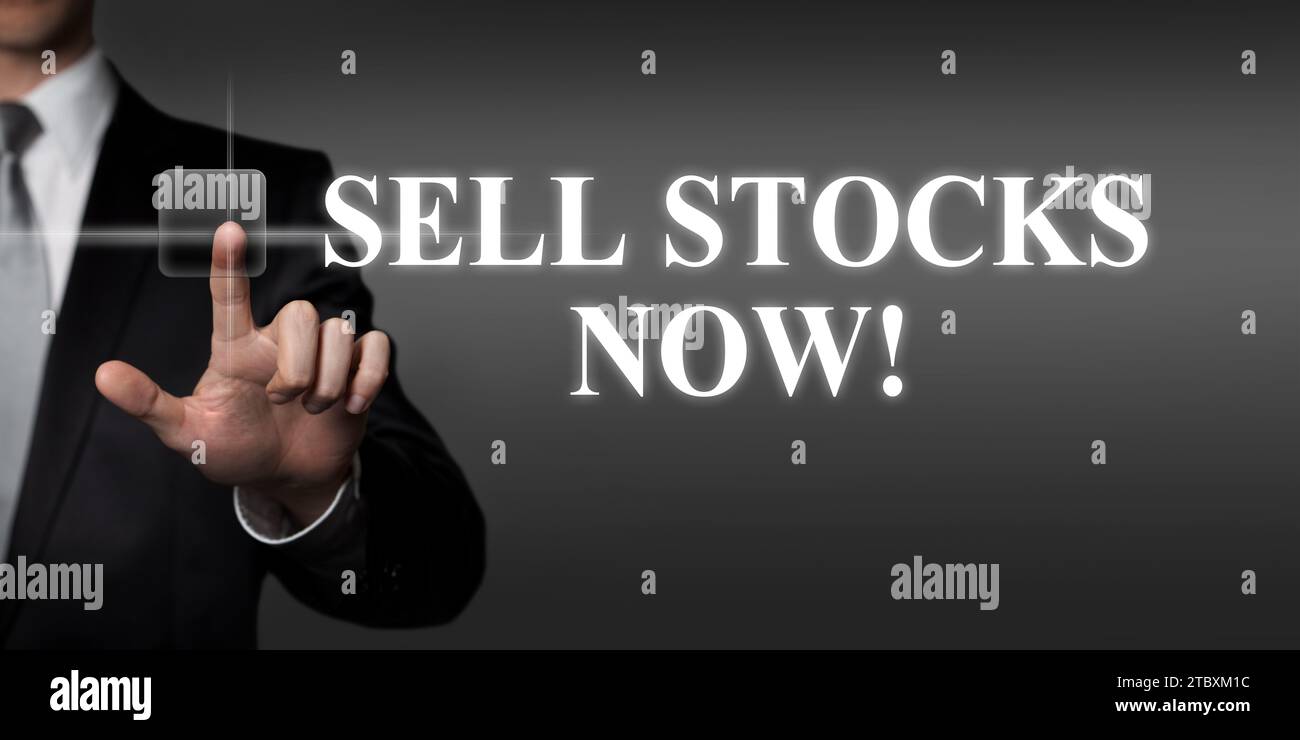 vendre des stocks maintenant - homme d'affaires appuyant sur le bouton tactile virtuel Banque D'Images