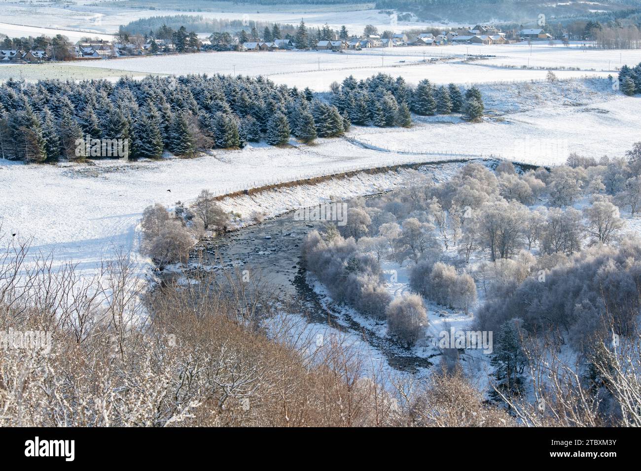 Rivière Avon avec le village de Tomintoul au loin dans la neige. Cairngorms, Highlands, Écosse Banque D'Images