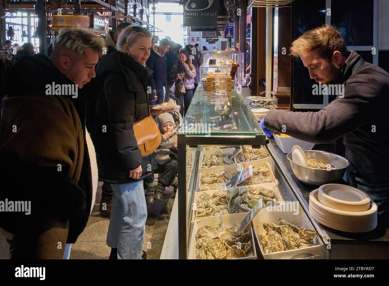 MADRID ESPAGNE - 09 DÉCEMBRE 2023 : étal d'huîtres fraîches au marché de San Miguel à Madrid, Espagne. Les gens se rassemblent autour du stand, regardant le seletti Banque D'Images