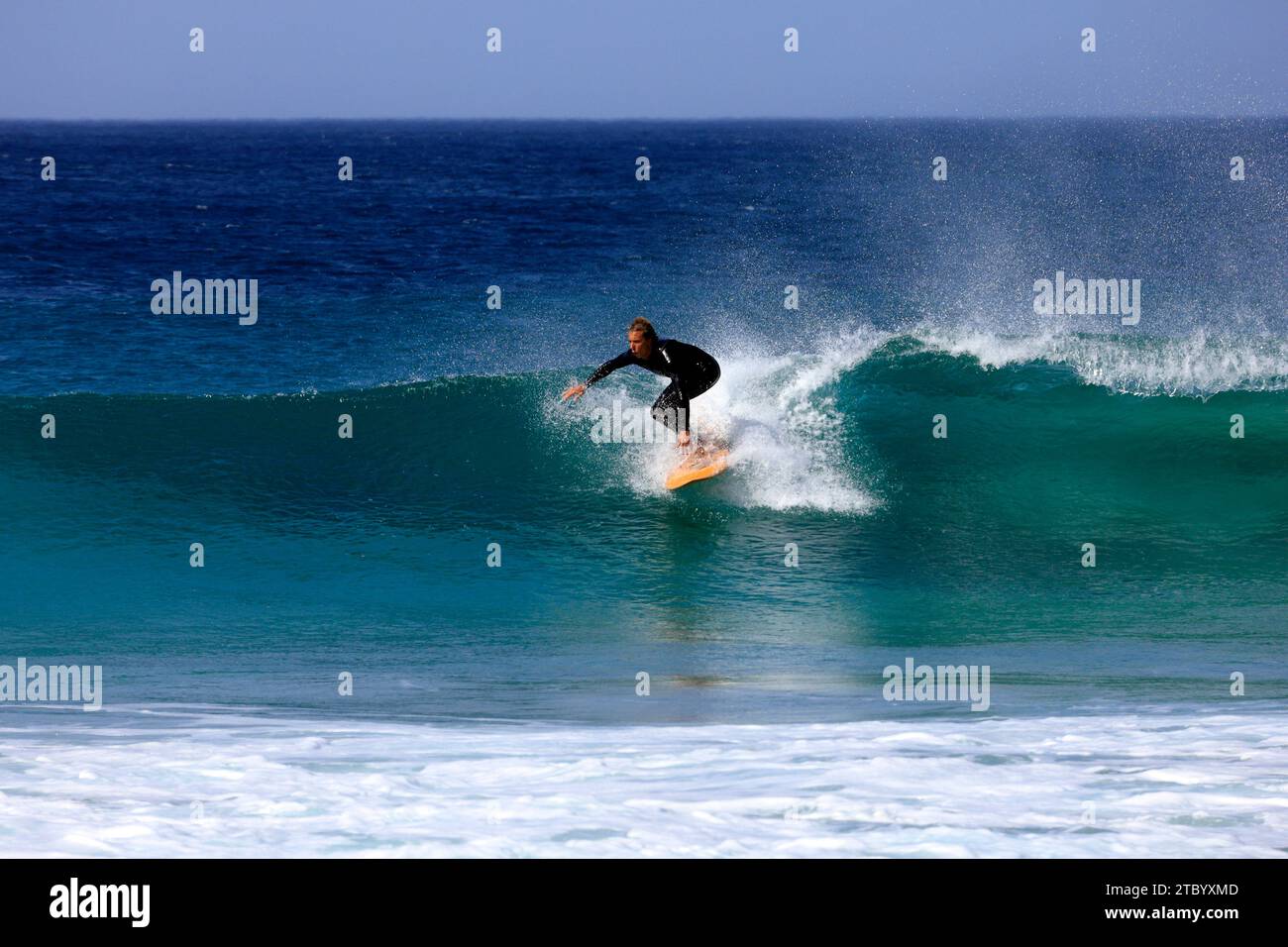 Surfeur compétent sur une vague balayée par le vent, à El Cotillo, Fuerteventura, Îles Canaries, Espagne. Prise en novembre 2023 Banque D'Images