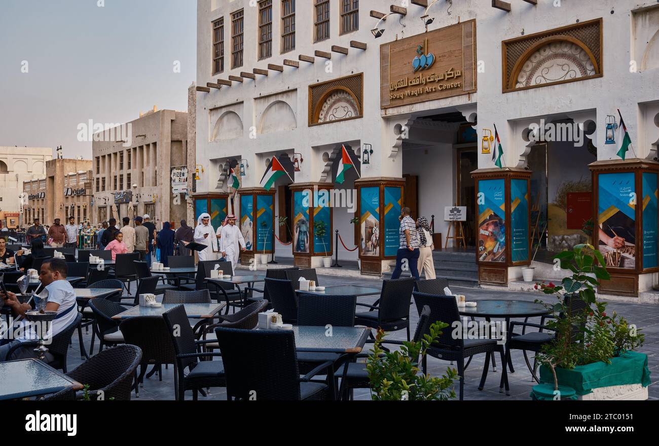 Souq Waqif à Doha, Qatar rue principale après-midi photo montrant le centre d'art Souq Waqif, des restaurants, des gens marchant et le drapeau du Qatar Banque D'Images
