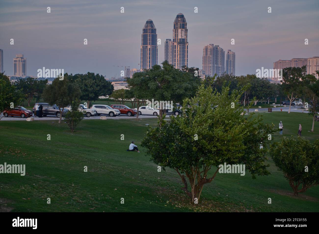 La tour UDC et la perle Skyline , des collines Katara à Doha, Qatar coucher de soleil tourné avec des arbres au premier plan et des nuages dans le ciel en arrière-plan Banque D'Images