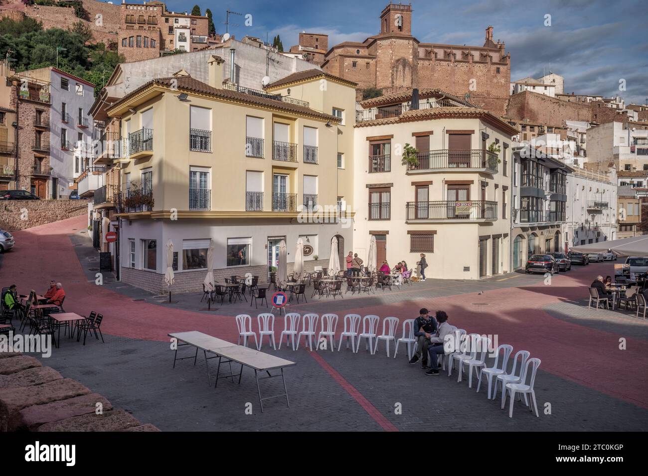Couple assis sur une scène avec des chaises blanches dans une rangée parlant amicalement sur la place de la ville de Villafames (Vilafames) province de Castellon, Espagne, Europe. Banque D'Images