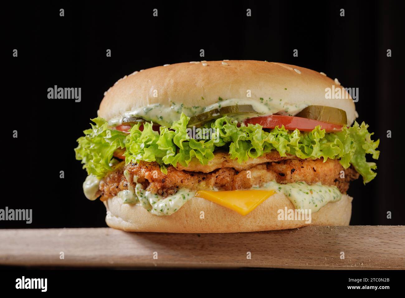 parfait savoureux grand cheeseburger de poulet sur la table en bois sur fond brun Banque D'Images