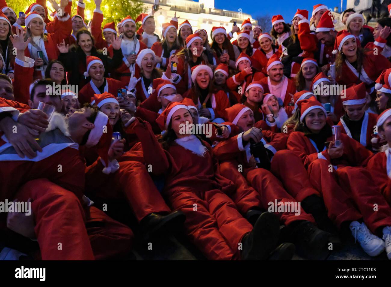 Londres, Royaume-Uni. 9 décembre 2023. Les fêtards de SantaCon vêtus de costumes du Père Noël et d'autres costumes festifs arrivent à Trafalgar Square où ils ont posé pour des photos de groupe au pied de la colonne Nelson. L’événement annuel, qui voit les participants prendre part à un pub crawl, est également organisé dans d’autres villes du monde. Crédit : Photographie de onzième heure / Alamy Live News Banque D'Images