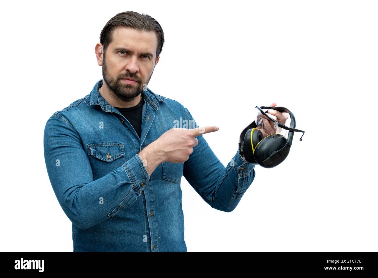 Un homme sérieux indiquant que des accessoires de sécurité industrielle devraient être utilisés. Banque D'Images