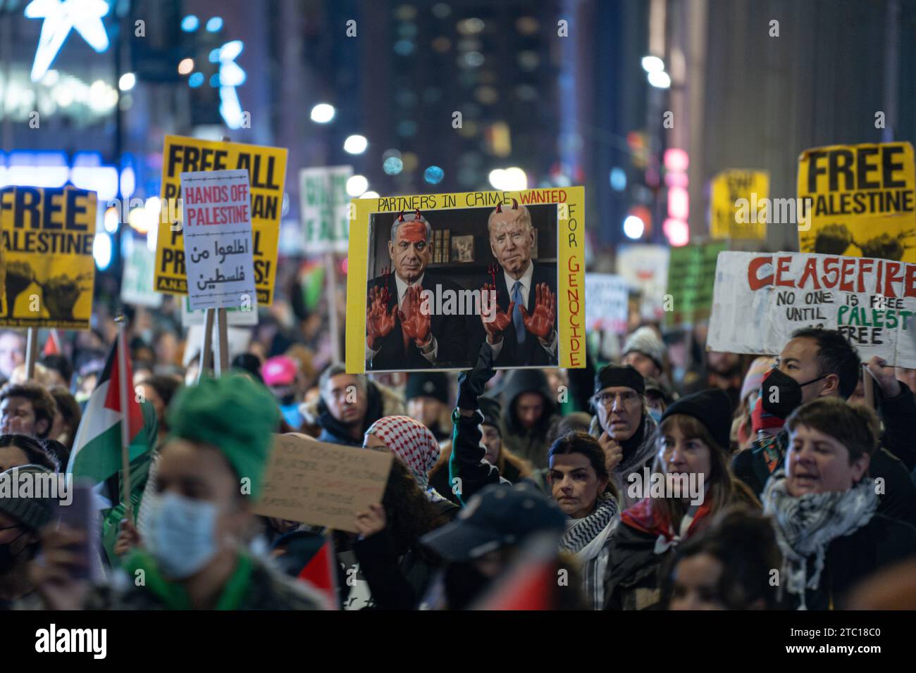 New York, États-Unis. 08 décembre 2023. Un panneau avec le Premier ministre israélien Benjamin Netanyahu et le président américain Joe Biden avec des mains rouges et des cornes rouges, indiquant «partenaires dans le crime. Recherché pour génocide". Des manifestants pro-palestiniens défilent pour protester contre les États-Unis et les entreprises américaines pour leur soutien à Israël pendant le conflit israélo-palestinien. La manifestation s'est poursuivie au-delà de Wall Stret après que les organisateurs aient entendu parler de leur veto des États-Unis au projet de résolution du Conseil de sécurité de l'ONU qui appelle à un cessez-le-feu immédiat. Crédit : SOPA Images Limited/Alamy Live News Banque D'Images