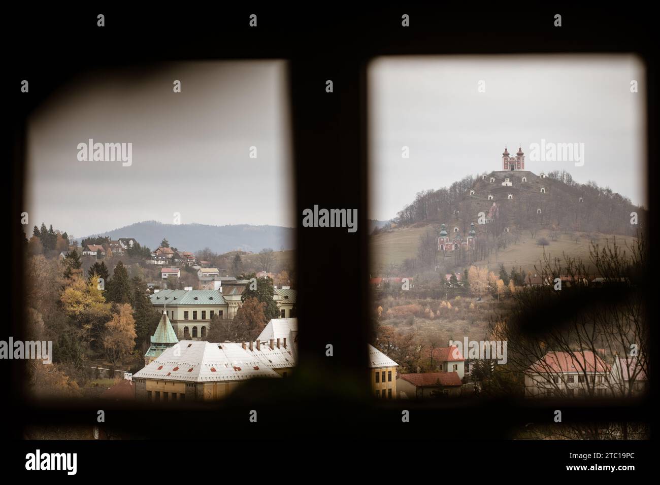 Vue panoramique de derrière la fenêtre sur la ville de Banská Štiavnica dans le centre de la Slovaquie avec son symbole emblématique - le Calvaire de Banská Štiavnica Banque D'Images