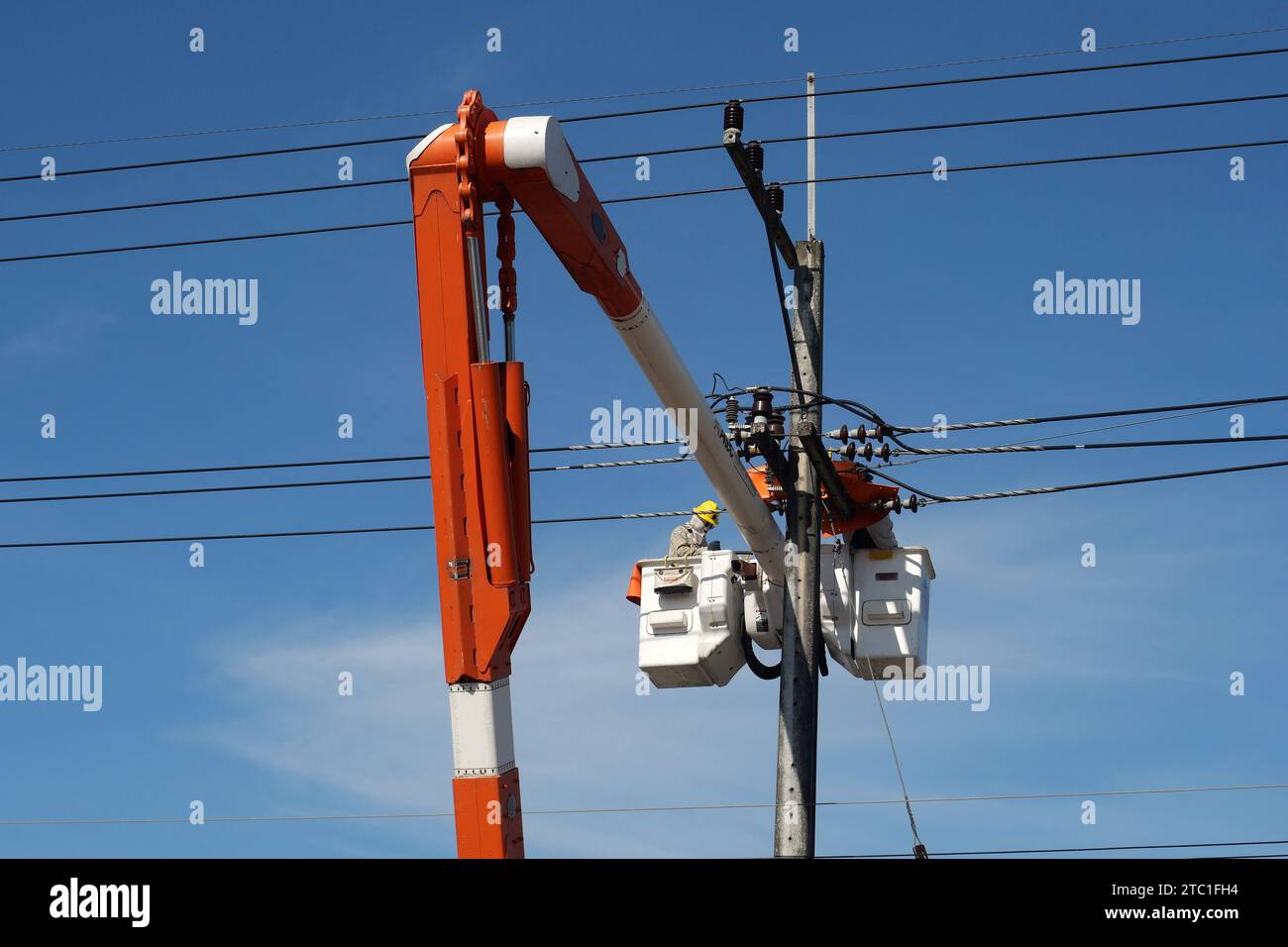 CHIANG MAI, THAÏLANDE 14 novembre 2023 : un électricien répare des fils électriques à haute tension. Banque D'Images