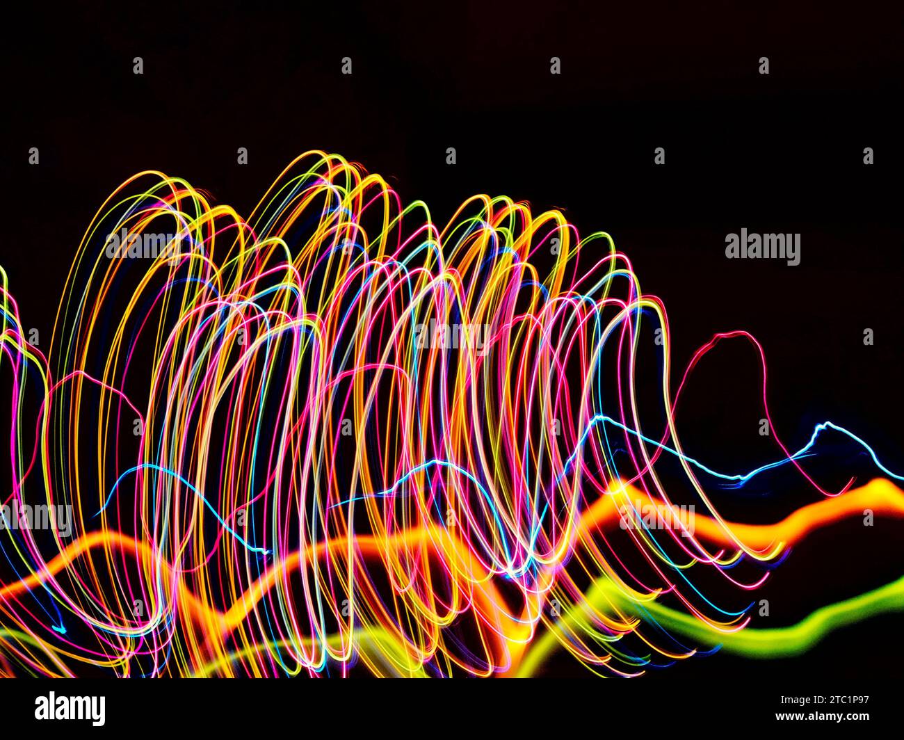 Longues traînées lumineuses d'exposition de lumière rose, orange, jaune et bleue Banque D'Images