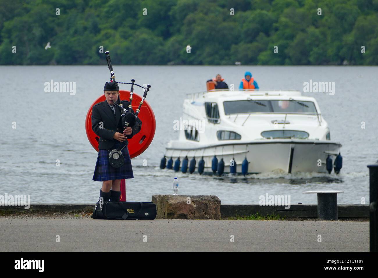 Fort Augustus, Écosse - juillet 26 2016 : cornemuse écossais en robe traditionnelle jouant devant le lac du Loch Ness connu pour son monstre mythique Banque D'Images