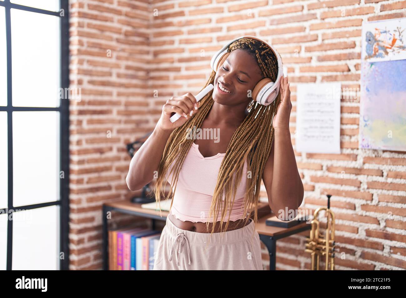 Femme afro-américaine écoutant de la musique chantant à la maison Banque D'Images