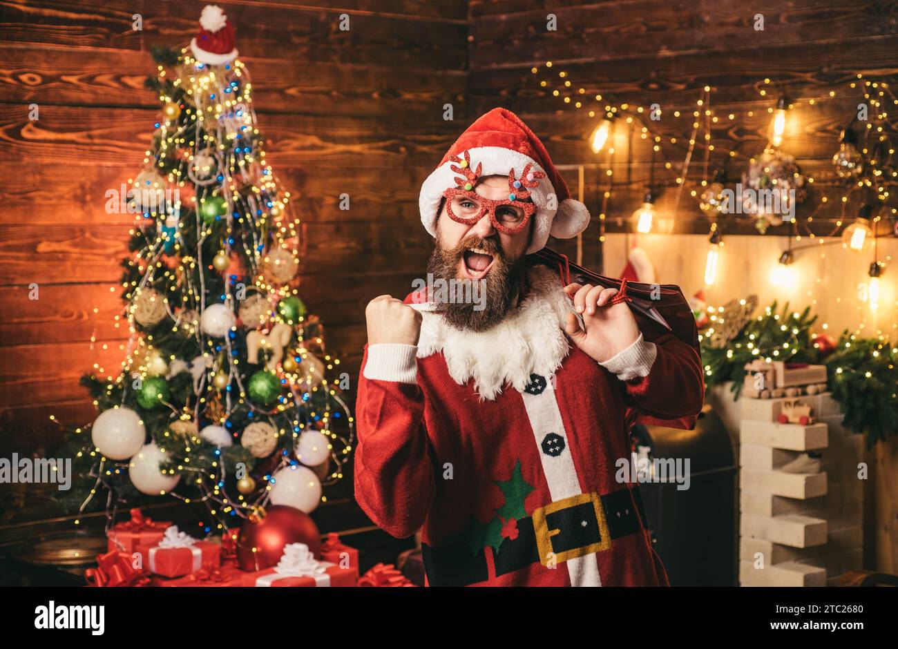 Joyeux Pere Noel habille en vetements d hiver pensez a Noel pres de l arbre de Noel. Portrait d un pere Noel mature brutal Photo Stock Alamy