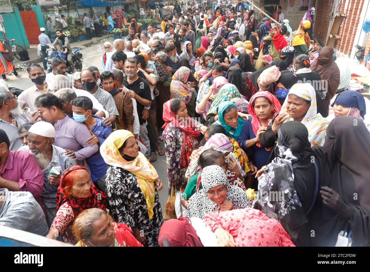 Dhaka, Bangladesh - 10 décembre 2023 : comme le prix de l'oignon a doublé en un jour, les gens ordinaires sont debout dans de longues files d'attente pour acheter de l'huile, des légumineuses, p Banque D'Images
