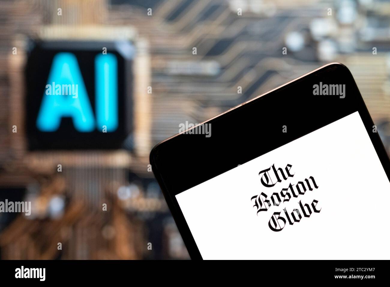 Dans cette illustration photo, le logo du quotidien américain The Boston Globe est affiché sur un smartphone avec une puce d'intelligence artificielle (IA) et un symbole en arrière-plan. Banque D'Images