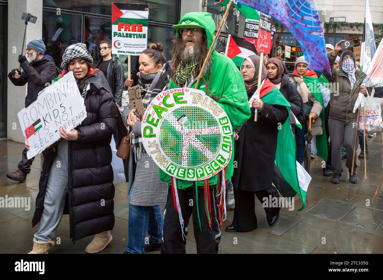 Londres / Royaume-Uni - 9 2023 décembre : un manifestant pro-palestinien anglais barbu tient une bannière sur laquelle on peut lire « Peace, respect Life » avec un logo CND lors d'une manifestation c Banque D'Images