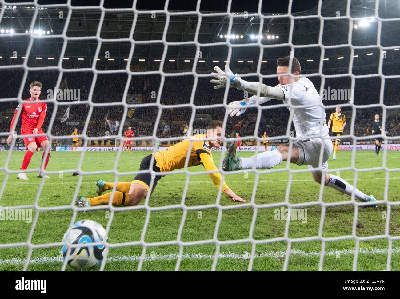 10 décembre 2023, Saxe, Dresde : football : 3e division, SG Dynamo Dresden - SpVgg Unterhaching, match 18, Rudolf-Harbig-Stadion. Jakob Lemmer (l) de Dynamo marque le but contre le gardien de but de Unterhaching René Vollath pour un score de 1:0. Photo : Robert Michael/dpa/ZB Banque D'Images