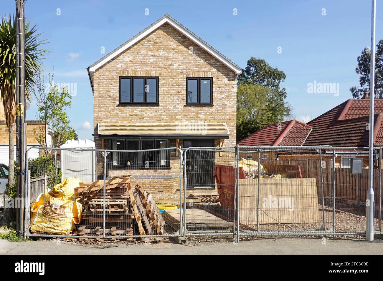 Série de 37 images travail en cours sur les étapes finales de maison individuelle et travaux externes commencés montre la clôture de sécurité du site adéquate pour le village rural UK Banque D'Images