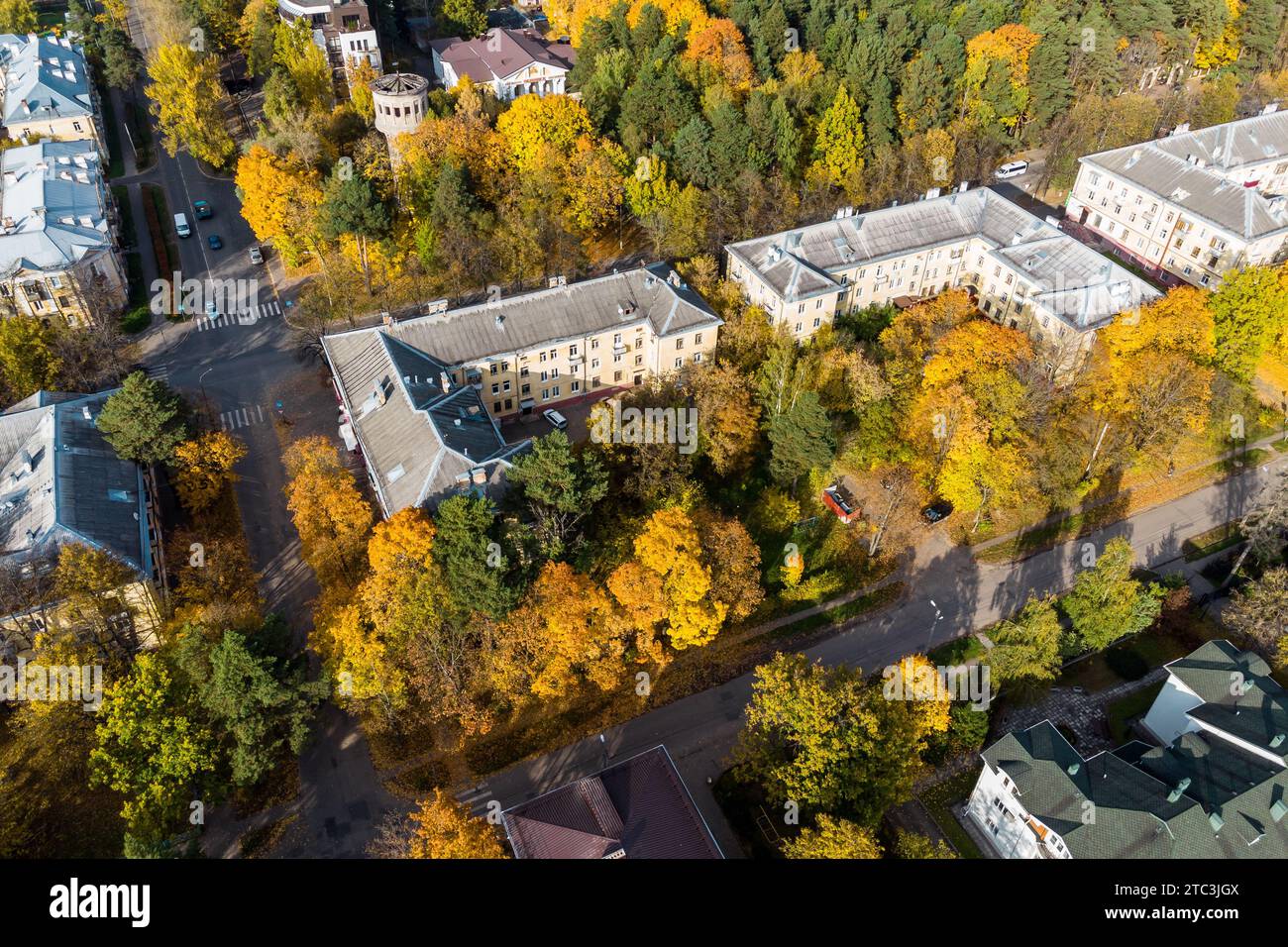 Vol de drone au-dessus d'un quartier résidentiel de la ville avec des bâtiments de moyenne hauteur aux couleurs automnales Banque D'Images