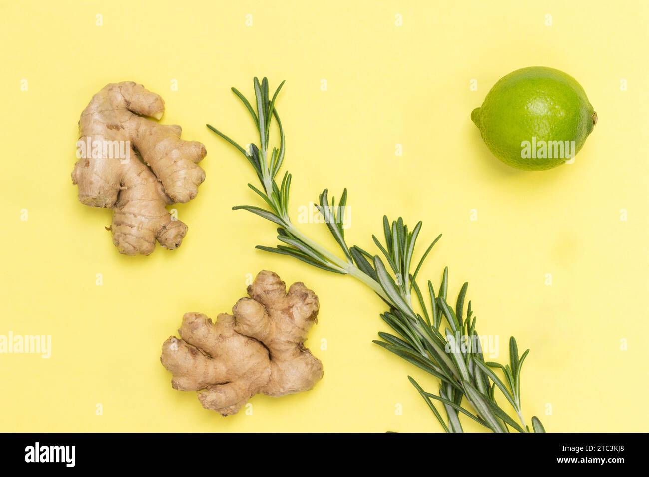 Gingembre, branche de romarin et citron vert. Remède alternatif contre le rhume et la grippe. Les soins de santé. Fond jaune. Pose à plat Banque D'Images