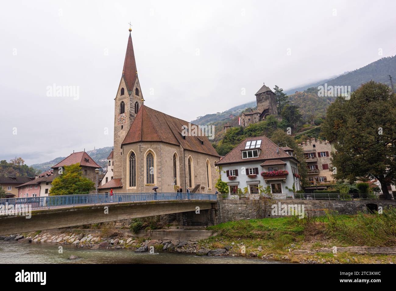 Église Sainte-Andrea à Chiusa (allemand : Klausen), Italie avec pont sur la rivière Isarco (allemand : Eisack). Banque D'Images