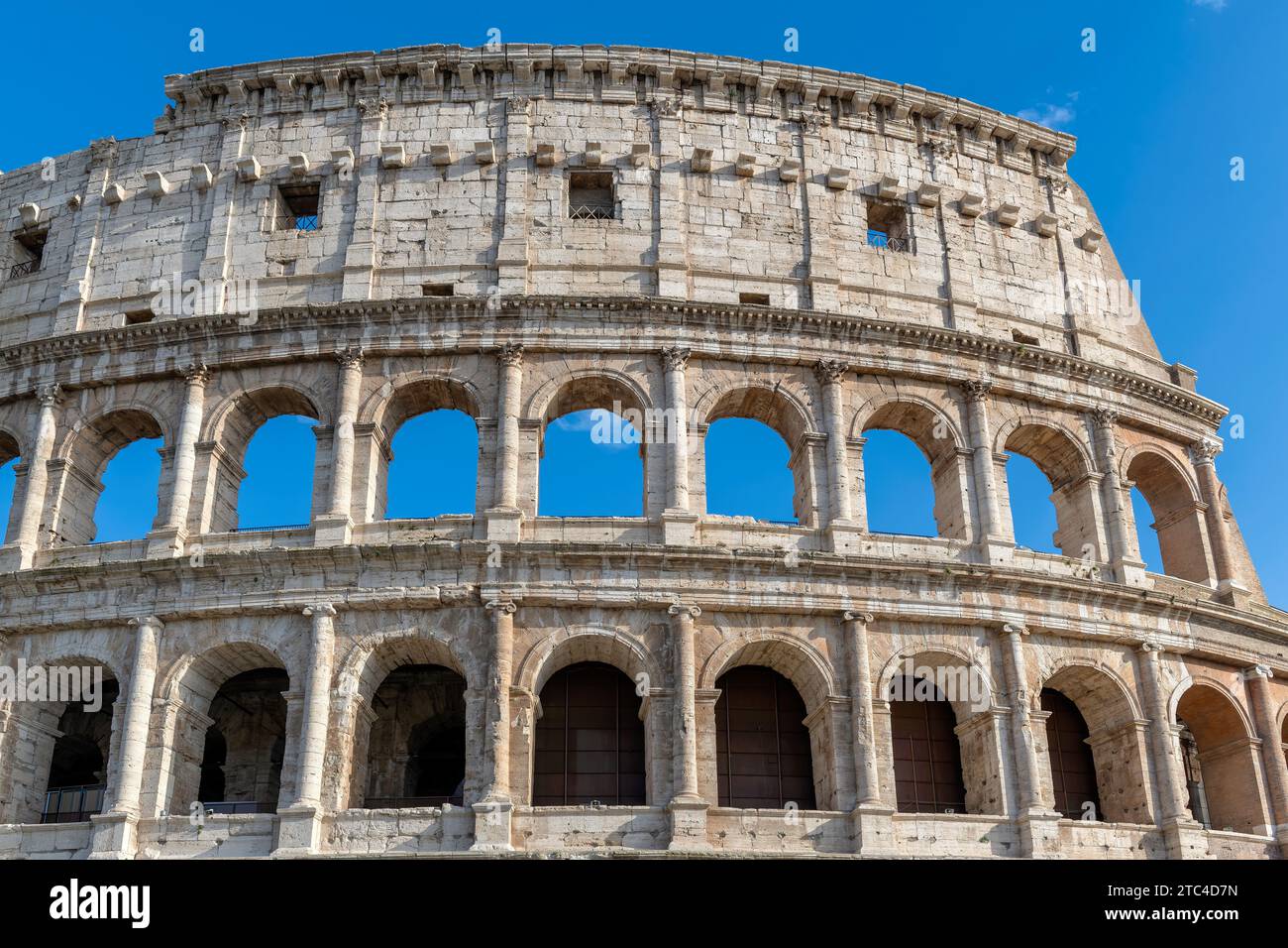 Bâtiments du Colisée avec des arches situées contre le ciel bleu dans la rue de Rome, Italie. Banque D'Images