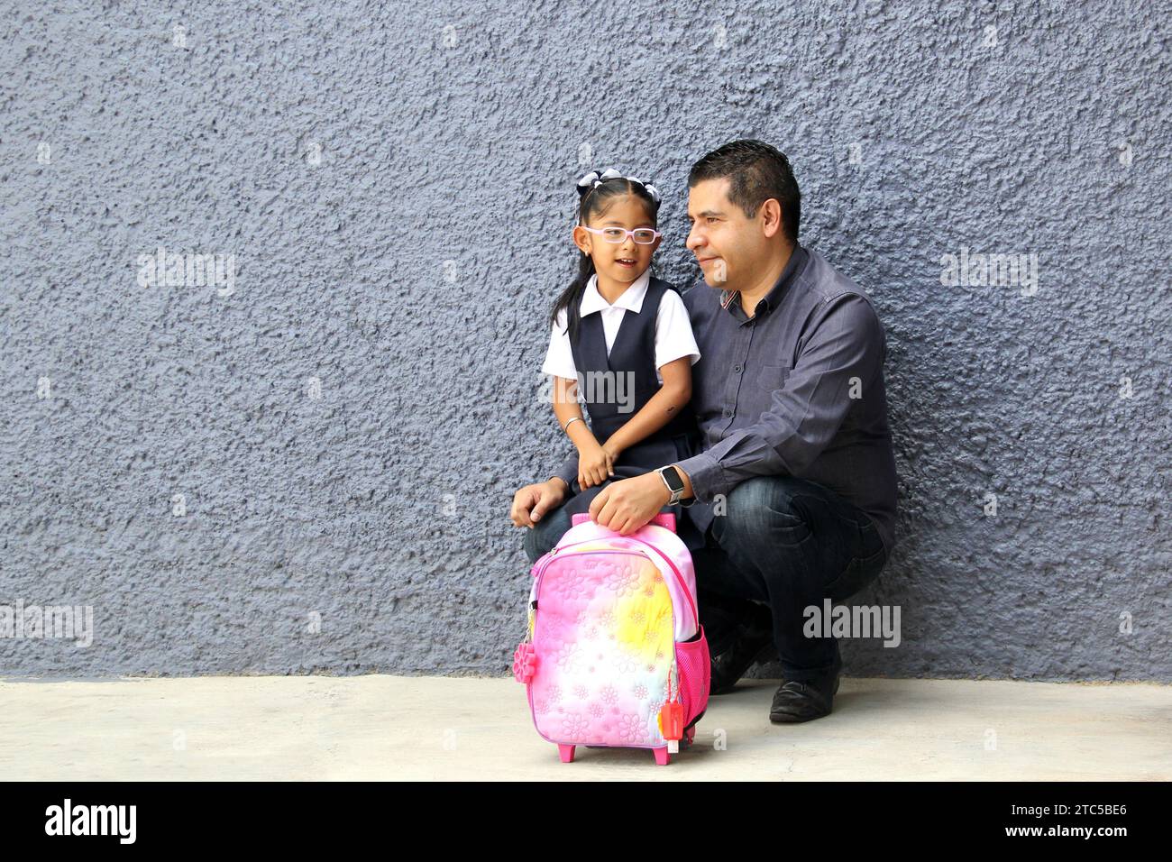 Un père célibataire divorcé va chercher sa fille de 4 ans en uniforme à l'école, les Latinos à la peau foncée parlent pour prévenir les abus et la violence Banque D'Images Un père célibataire divorcé va chercher sa fille de 4 ans en uniforme à l'école, les Latinos à la peau foncée parlent pour prévenir les abus et la violence Banque D'Images
