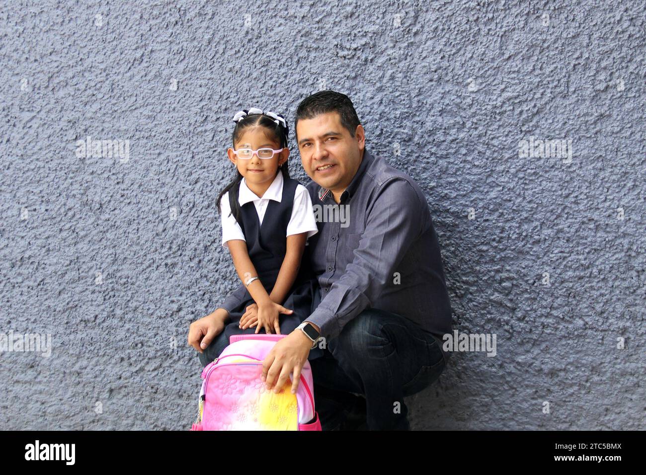 Un père célibataire divorcé va chercher sa fille de 4 ans en uniforme à l'école, les Latinos à la peau foncée parlent pour prévenir les abus et la violence Banque D'Images Un père célibataire divorcé va chercher sa fille de 4 ans en uniforme à l'école, les Latinos à la peau foncée parlent pour prévenir les abus et la violence Banque D'Images