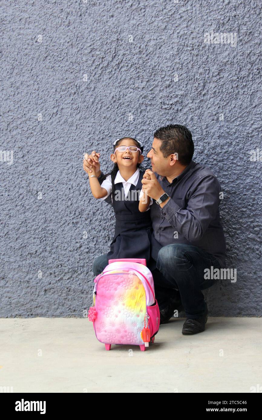 Un père célibataire divorcé va chercher sa fille de 4 ans en uniforme à l'école, les Latinos à la peau foncée parlent pour prévenir les abus et la violence Banque D'Images Un père célibataire divorcé va chercher sa fille de 4 ans en uniforme à l'école, les Latinos à la peau foncée parlent pour prévenir les abus et la violence Banque D'Images