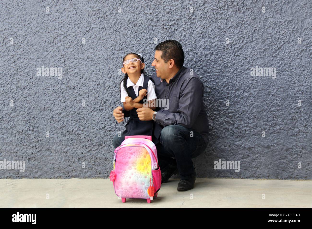 Un père célibataire divorcé va chercher sa fille de 4 ans en uniforme à l'école, les Latinos à la peau foncée parlent pour prévenir les abus et la violence Banque D'Images Un père célibataire divorcé va chercher sa fille de 4 ans en uniforme à l'école, les Latinos à la peau foncée parlent pour prévenir les abus et la violence Banque D'Images