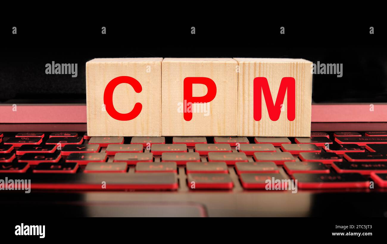 CPM coût par mile écrit sur des cubes en bois sur le clavier de l'ordinateur portable Banque D'Images