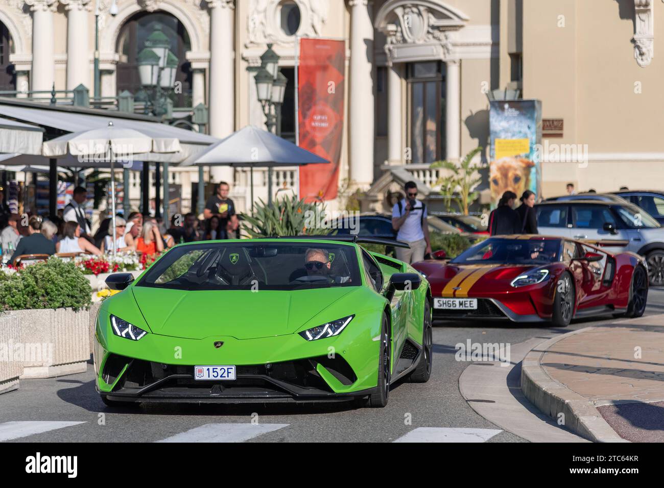 Monaco, Monaco - Green Lamborghini Huracán performante Spyder et Burgundy Ford GT conduisant sur la place du Casino. Banque D'Images