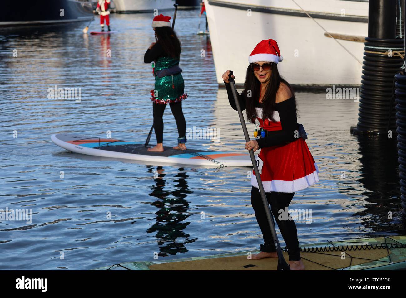 Santa Barbara, Californie, États-Unis 10 décembre 2023. Une femme dans une robe du Père Noël sur un Paddle Board au DÉFILÉ DE LUMIÈRES KAYAK & SUP au port de Santa Barbara le 10 décembre 2023, dans le cadre du Parade of Lights Festival. Des dizaines de personnes habillées en Père Noël et Elfes et ont monté sur des planches de paddle et des kayaks à travers le port. (Image de crédit : © Amy Katz/ZUMA Press Wire) USAGE ÉDITORIAL SEULEMENT! Non destiné à UN USAGE commercial ! Crédit : ZUMA Press, Inc./Alamy Live News Banque D'Images