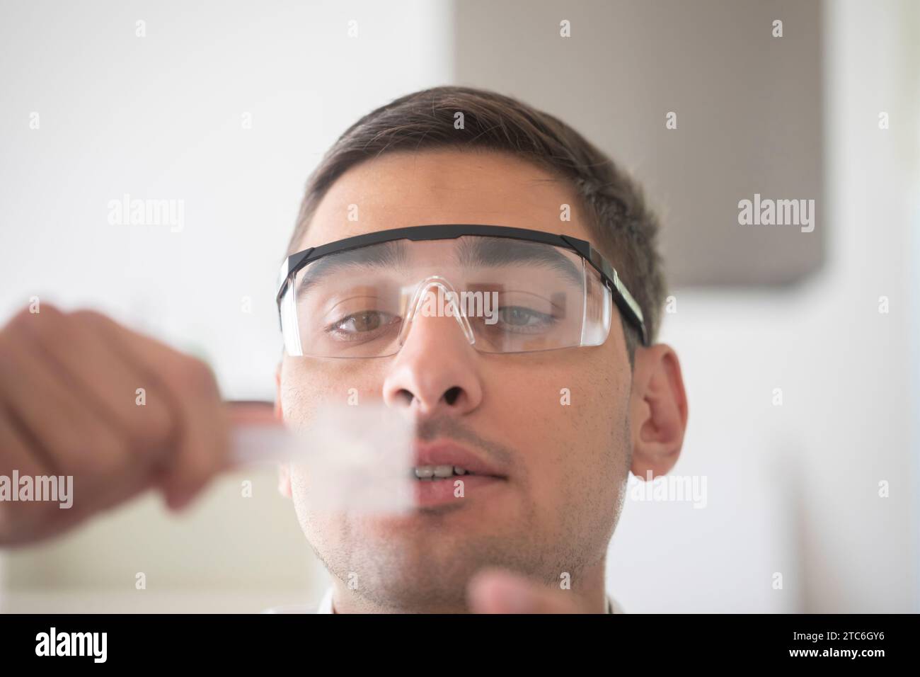 homme scientifique avec des lunettes de laboratoire travaillant avec un échantillon Banque D'Images