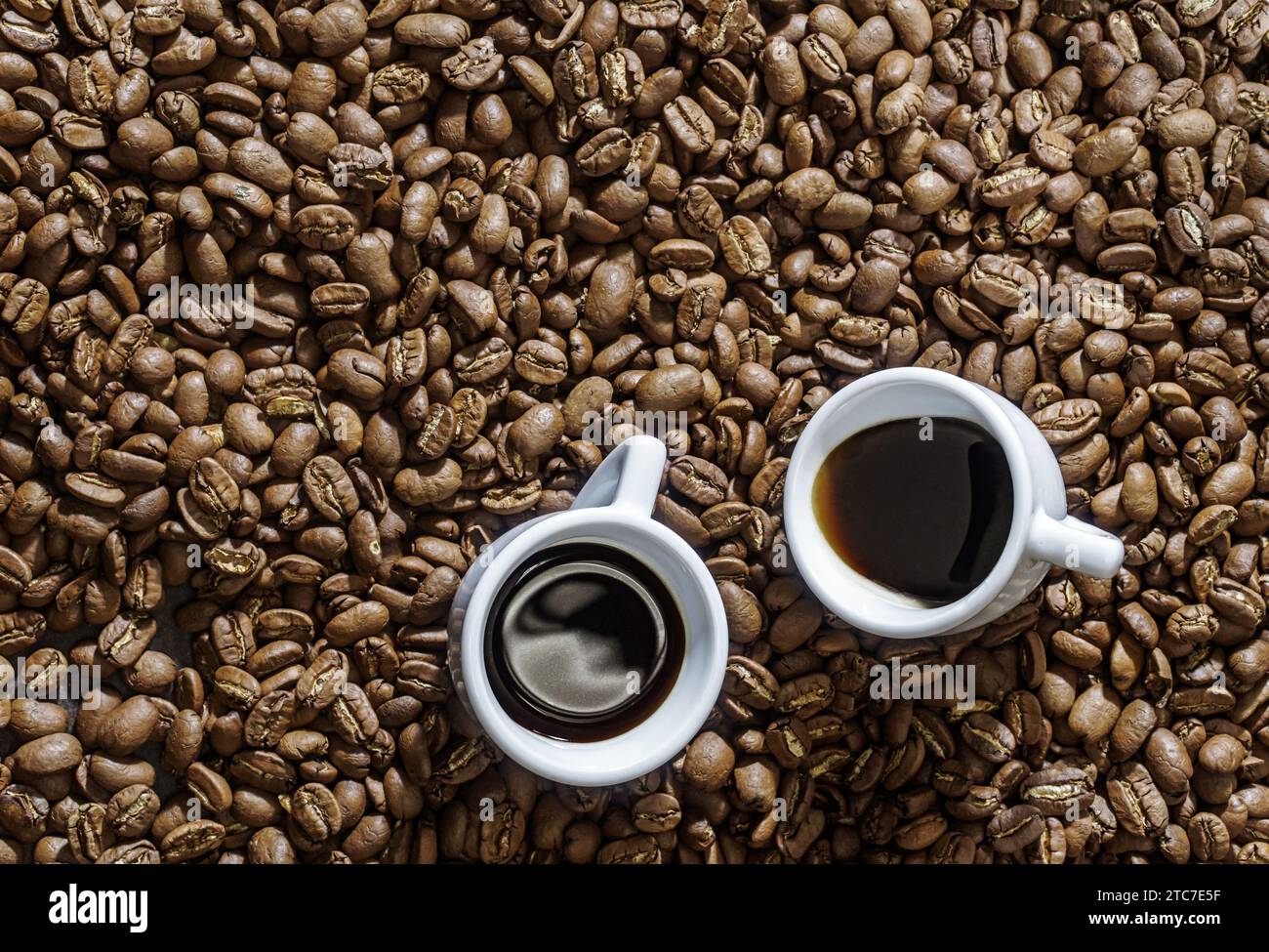 Deux tasses à espresso sur fond de grains de café vue de dessus Banque D'Images