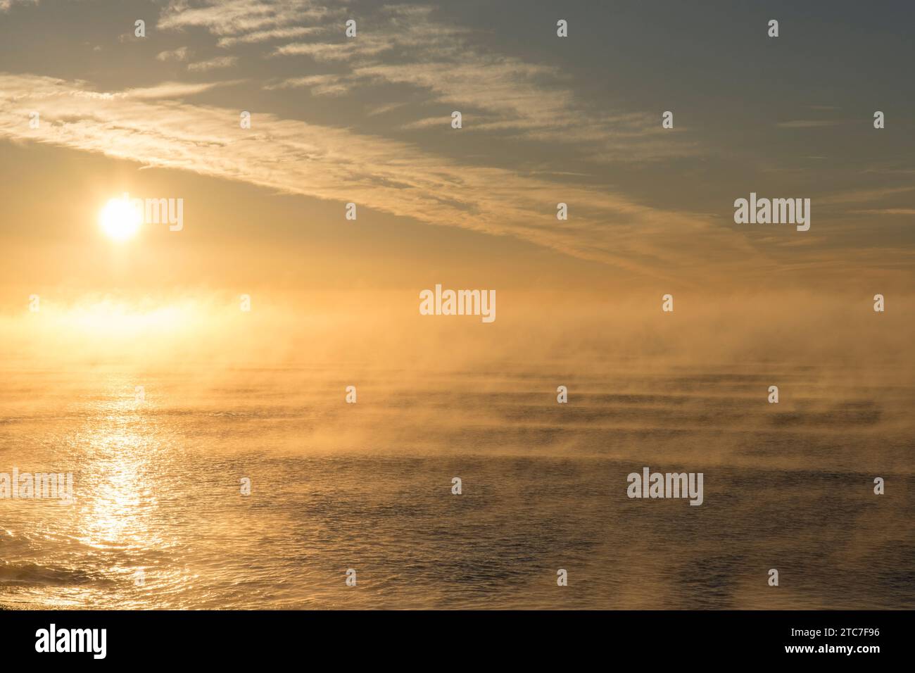 Brume de basse mer rampant sur la mer depuis la plage au lever du soleil froid et glacial à Seaton, Devon Banque D'Images
