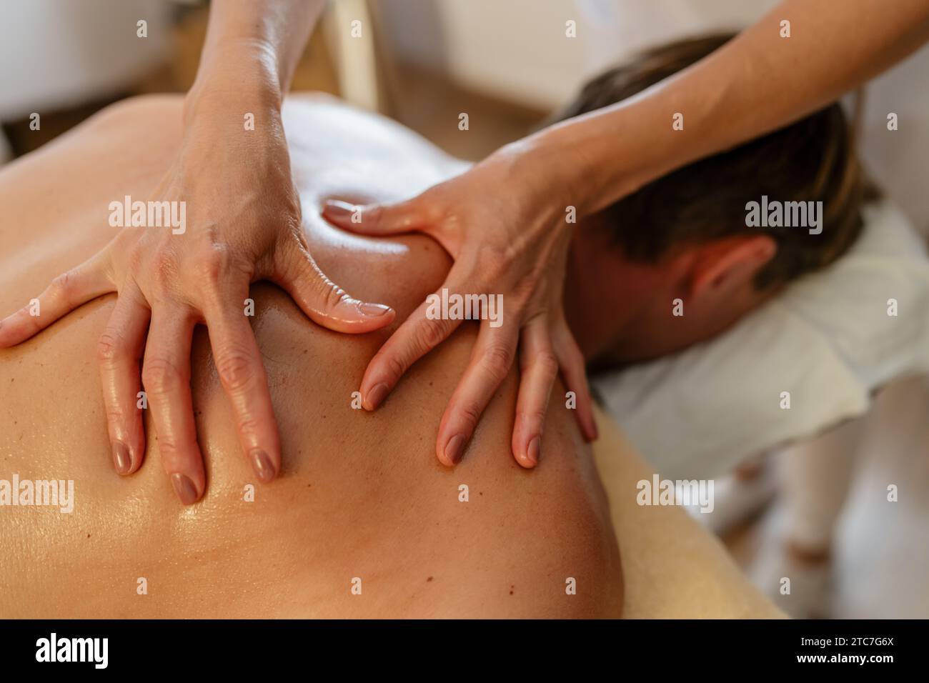 Gros plan d'un massothérapeute exerçant une pression sur le dos d'un client. Image conceptuelle du salon de beauté Wellness Hotel Banque D'Images