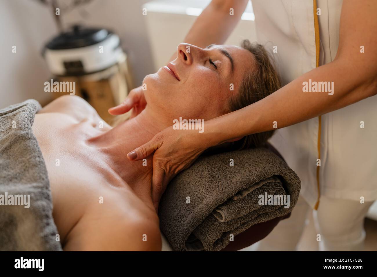 Femme recevant un massage relaxant du cou dans un spa avec les mains d'un thérapeute sur son épaule. Image conceptuelle du salon de beauté Wellness Hotel Banque D'Images