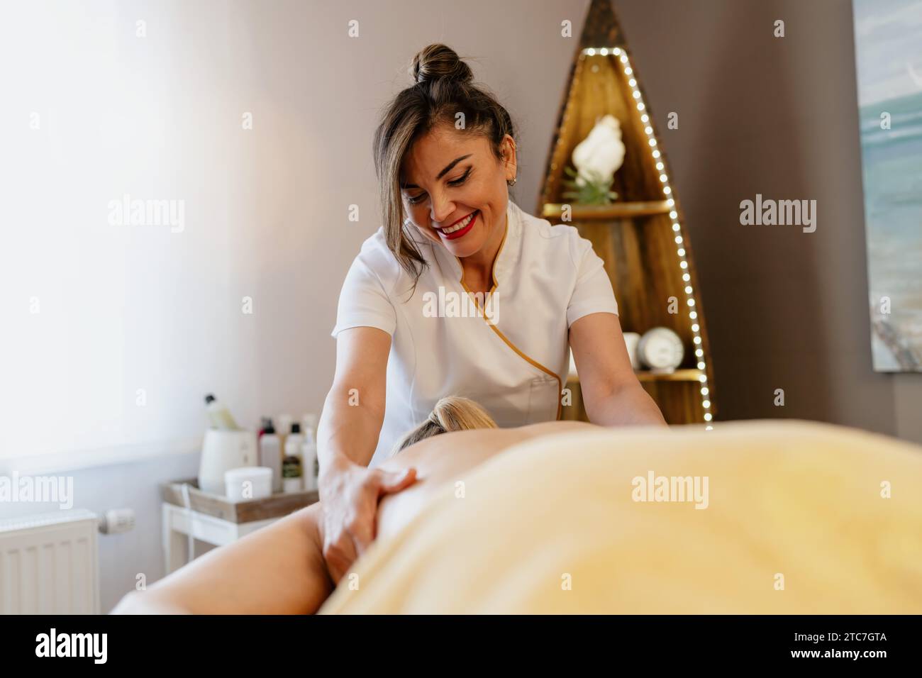 Joyeuse massothérapeute asiatique appliquant un massage du dos dans un spa salon de beauté confortable Wellness Hotel Banque D'Images