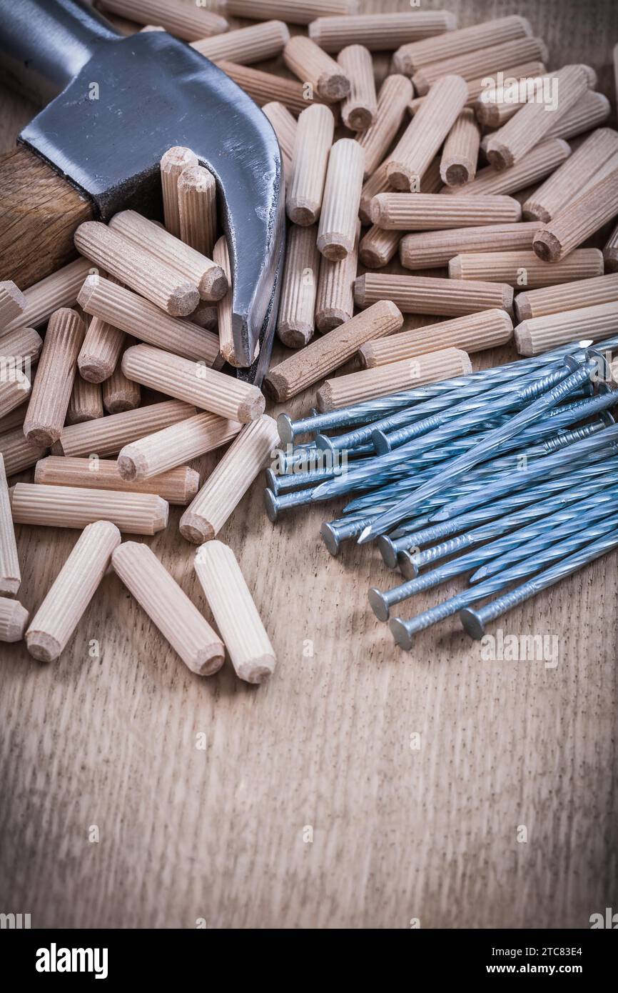 Chevilles en bois clous marteau sur planche de bois texturée Banque D'Images