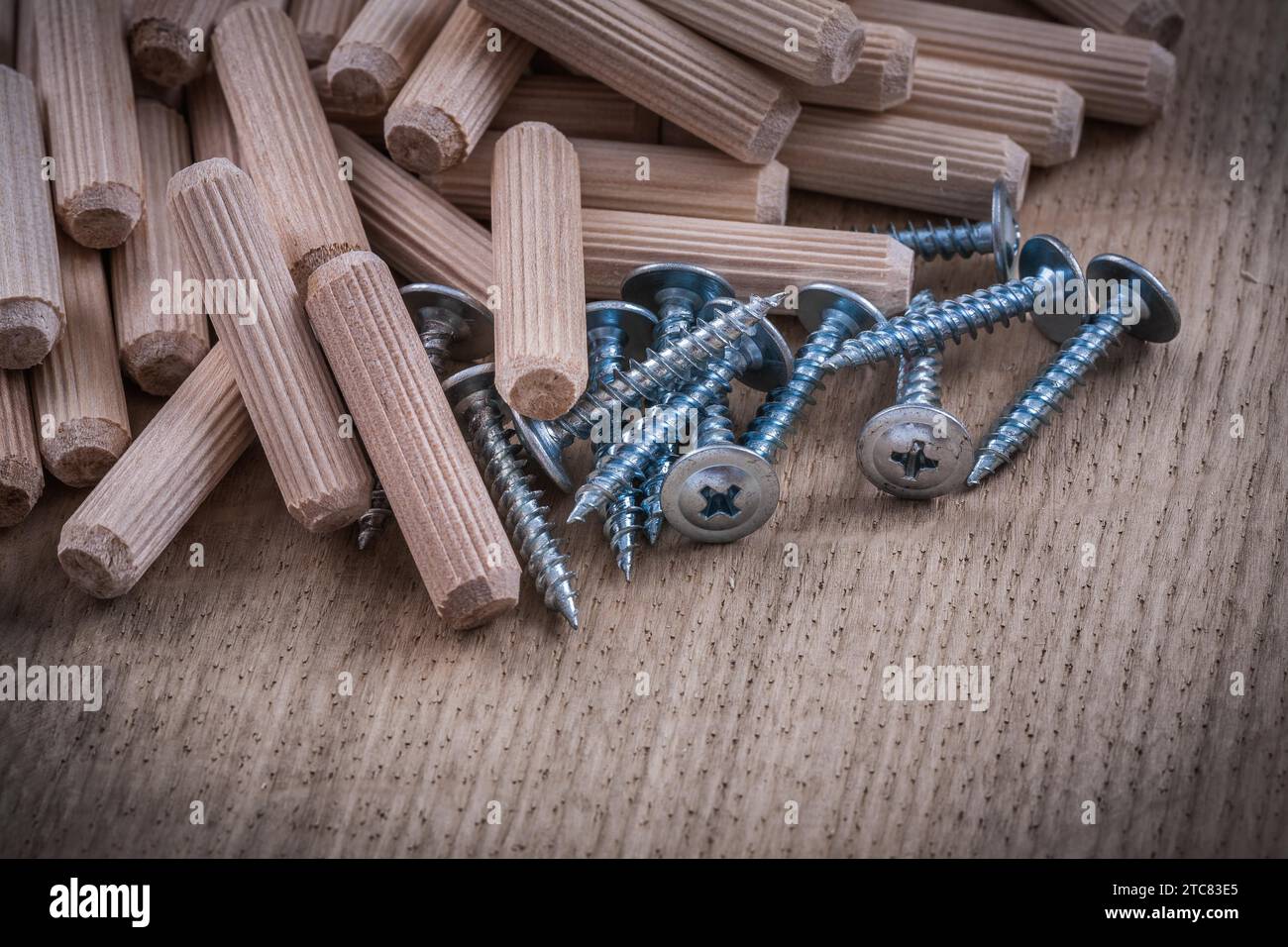 Chevilles en bois et clous de construction en métal sur planche de bois Banque D'Images