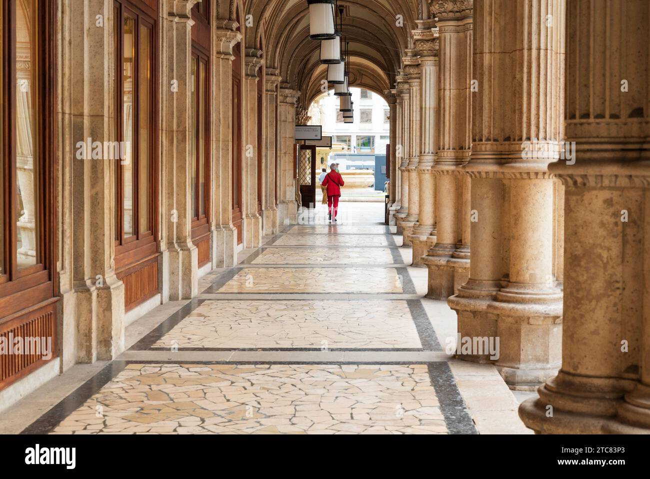 Vienne, Autriche 30 septembre 2023 personne en rouge marchant dans les arcades de l'opéra d'État Banque D'Images